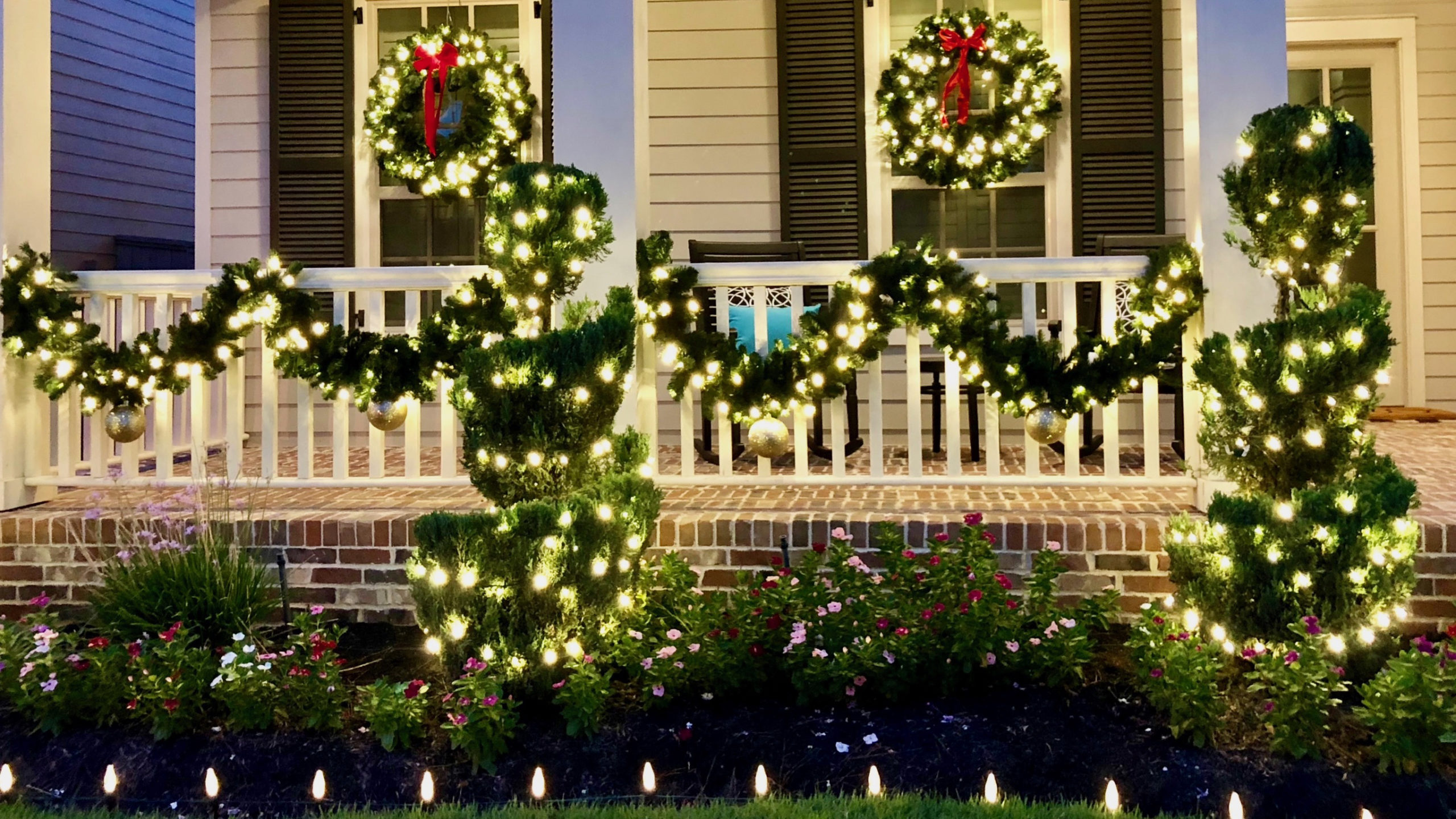 pre-lit garland and wreaths on porch