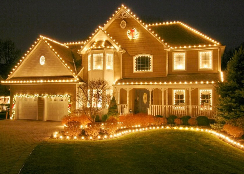 holiday lights on house and flower bed