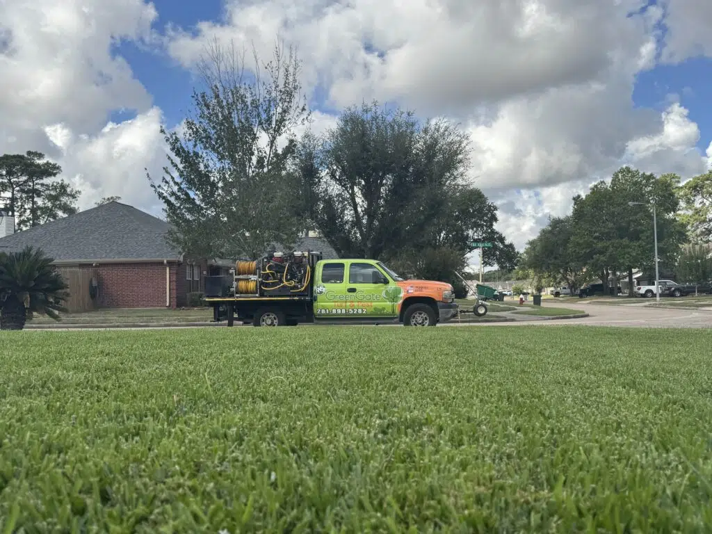 Greengate truck near a green lawn that just performed a lawn aeration (liquid aeration and plug aeration)