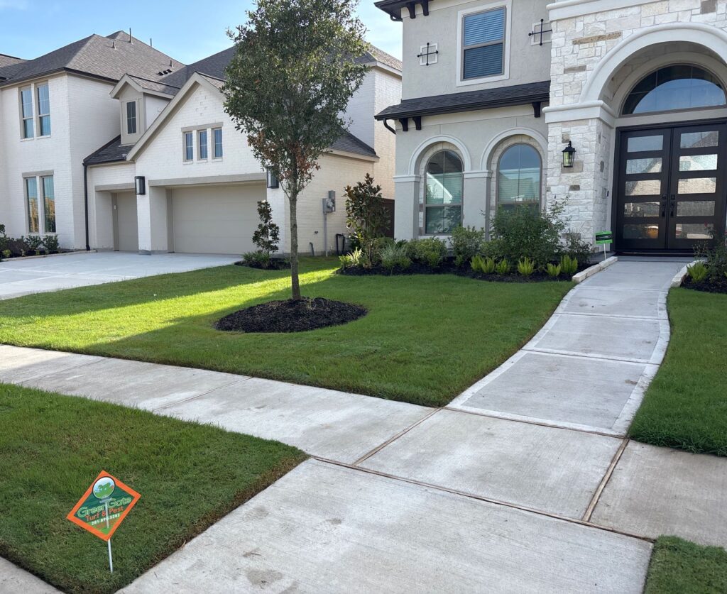 Green front lawn with a greengate sign in the front yard after a lawn fertilizer service