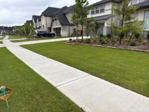 Green front lawn with a greengate sign in the grass after lawn fertilizer plan